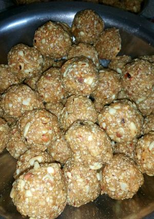 A picture of Til ladoos with coconut and nuts.