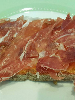 Una foto de Tostada con tomate, jamón y aceite de oliva virgen