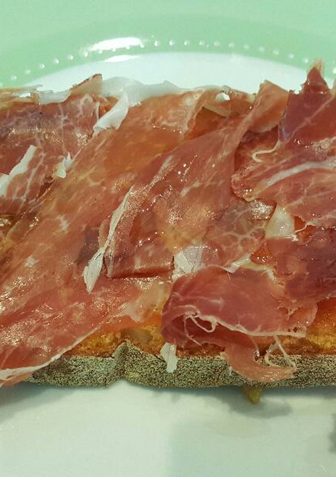Una foto de Tostada con tomate, jamón y aceite de oliva virgen