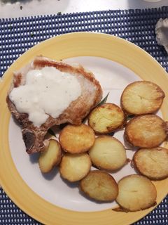 Una foto de Chuletas de cerdo con papas doradas y salsa de pimienta