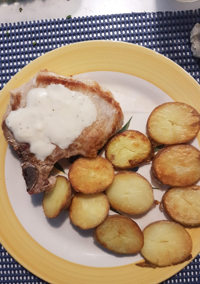 Una foto de Chuletas de cerdo con papas doradas y salsa de pimienta