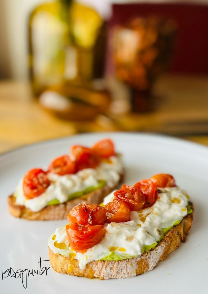 Una foto de Tostada de cherrys con burrata y mantequilla de aguacate 🍞 🍅 🥑