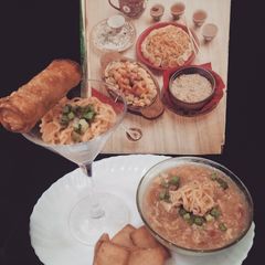 A picture of Noodle soup with spring roll on bed of noodles.