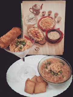 A picture of Noodle soup with spring roll on bed of noodles.
