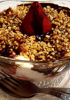 Una foto de Fresas con cuajada, salsa de chocolate y almendras