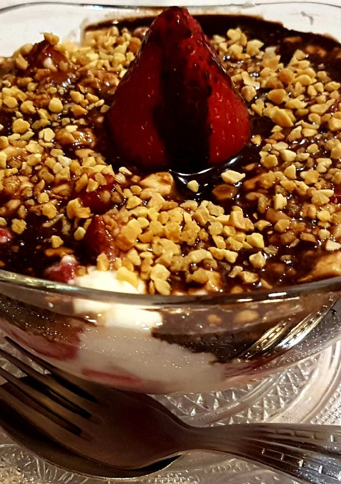 Una foto de Fresas con cuajada, salsa de chocolate y almendras