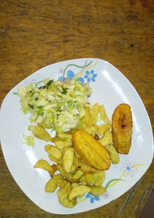 A picture of Fried irish potatoes and plantain with stir fry veggies.