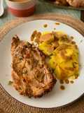 Chuletas, patata cocida y vinagreta agridulce de pepinillos con tomate seco