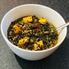 A picture of White Bean and Swiss Chard Egusi Soup with seed coated Polenta bites.