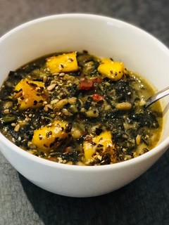 A picture of White Bean and Swiss Chard Egusi Soup with seed coated Polenta bites.