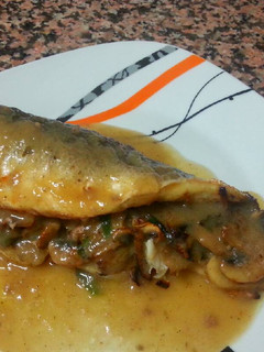 Una foto de Lubina al horno rellena de champiñones en su salsa