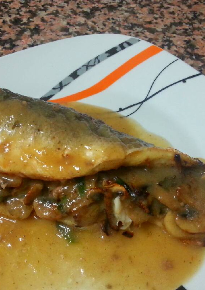 Una foto de Lubina al horno rellena de champiñones en su salsa