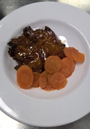 Una foto de Paleta de Cerdo Glaseada, Compota de Frutos Secos y Zanahorias en su Jugo