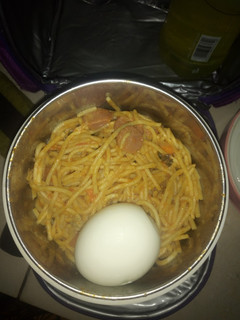 A picture of Jollof Spaghetti boiled egg and sausage.