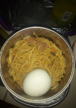 A picture of Jollof Spaghetti boiled egg and sausage.