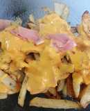 Papas Fritas en Salsa cheddar con panceta.