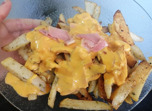 Una foto de Papas Fritas en Salsa cheddar con panceta.