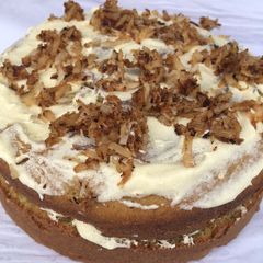 Coconut cake topped with caramelized coconut flakes A picture of Coconut cake topped with caramelized coconut flakes.