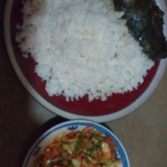 A picture of White rice with vegetable sauce served with cat fish.