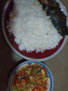 A picture of White rice with vegetable sauce served with cat fish.