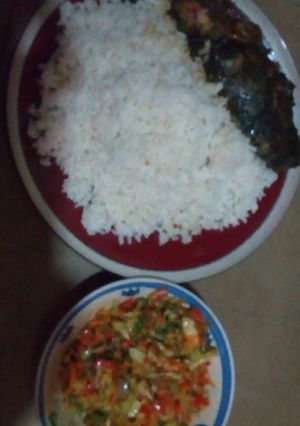 A picture of White rice with vegetable sauce served with cat fish.