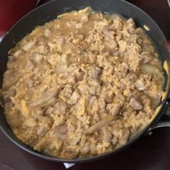 A picture of Bowl of rice topped with chicken and eggs.