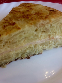 Una foto de Tortilla de papas rellena con queso y jamón