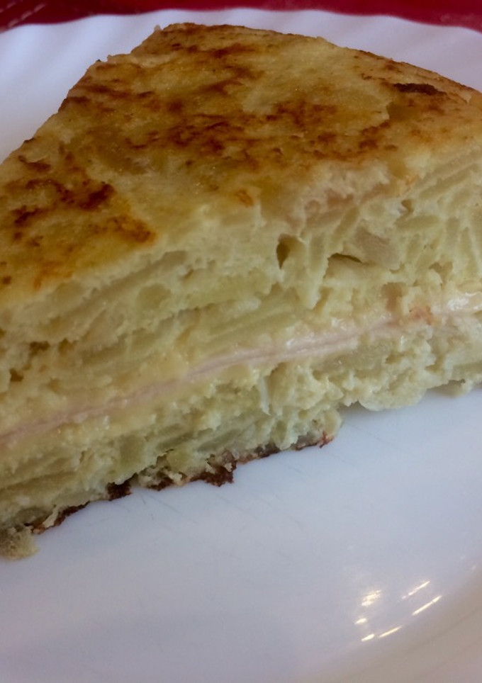 Una foto de Tortilla de papas rellena con queso y jamón