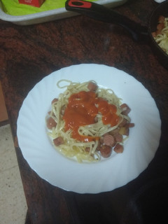 Una foto de Pasta frita y salteada con bacon, salchicha y tomate