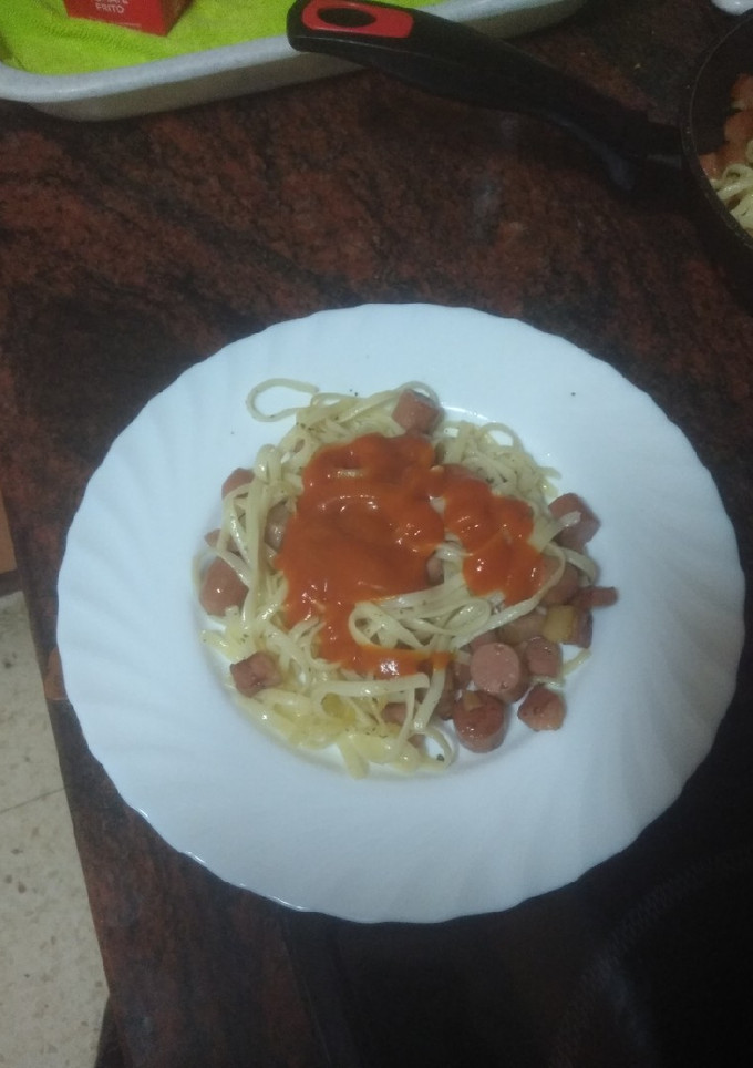 Una foto de Pasta frita y salteada con bacon, salchicha y tomate
