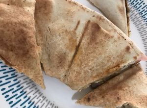 Una foto de Envuelto de cerdo con pan árabe y hummus
