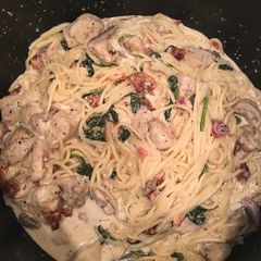 A picture of Chicken Spaghetti with Bacon, spinach, tomato, & mushrooms.