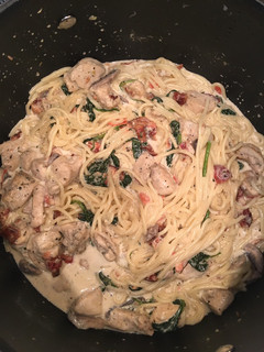 A picture of Chicken Spaghetti with Bacon, spinach, tomato, & mushrooms.