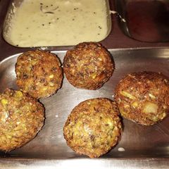 A picture of Whole moong and chana dal balls with coconut chutney.