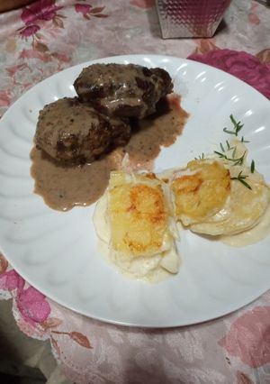 Una foto de Lomo a las 3 pimientas con milhojas de papas