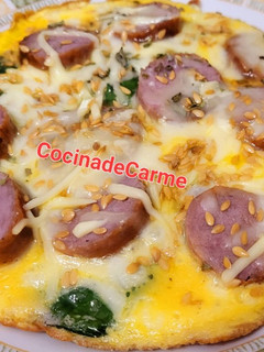 Una foto de Tortilla abierta de espinacas, butifarra y queso con semillas de lino