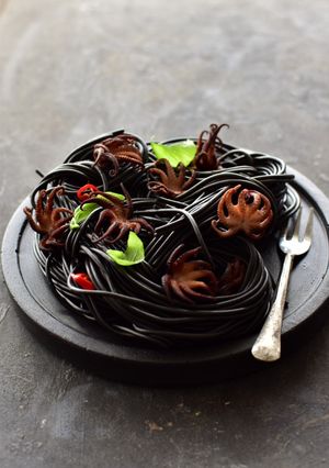 A picture of Marinated Baby Octopus and Squid Ink Pasta.