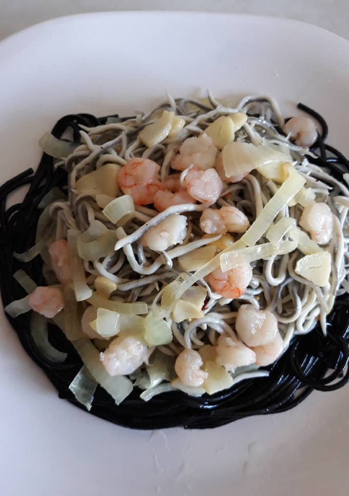 Una foto de Nido de Spaguettis al Nero di sepia con gulas y gambas
