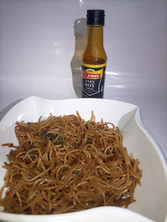 A picture of Brown spaghetti with spinach.