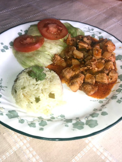 Una foto de Chuleta de cerdo guisada, arroz blanco, ensalada de lechuga y tomate