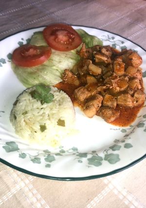 A picture of Braised Pork Chops, White Rice, Lettuce and Tomato Salad.