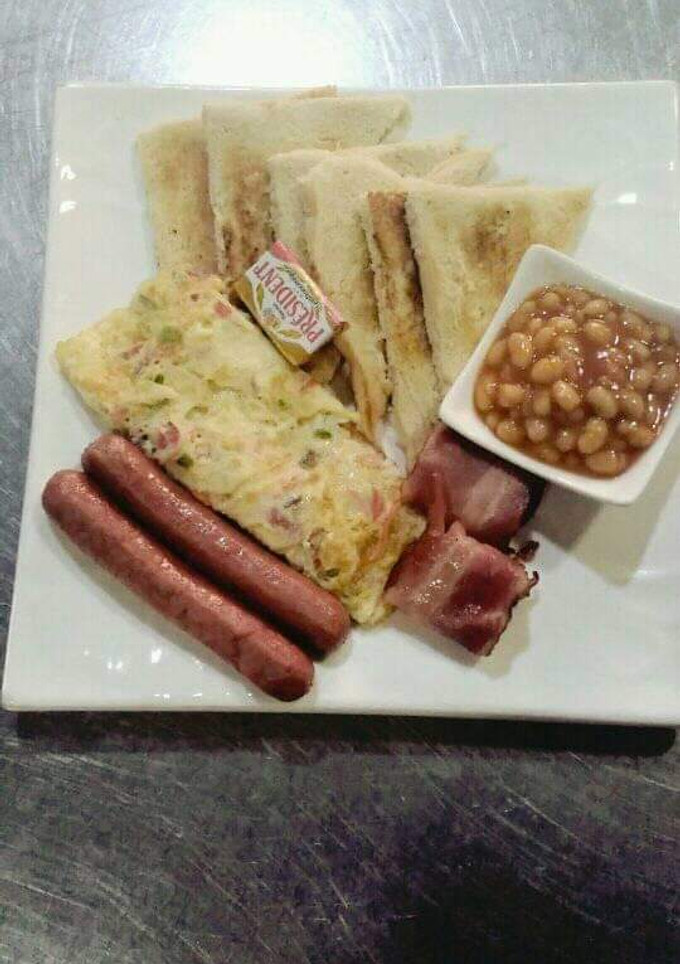 A picture of Sausages,omellete,bread and beans.