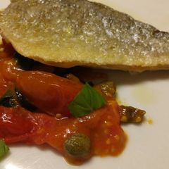 A picture of Pan fried sea bass with fresh tomatoes.