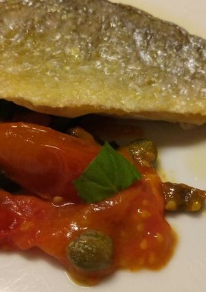 A picture of Pan fried sea bass with fresh tomatoes.