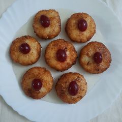 A picture of Coconut fritters deep in sugar syrup.