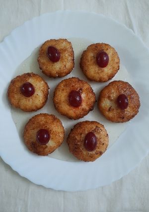 A picture of Coconut fritters deep in sugar syrup.