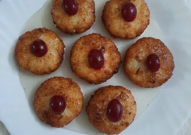 Coconut fritters deep in sugar syrup