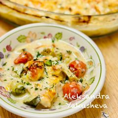 A picture of Chicken breast with vegetables in cheese sauce.