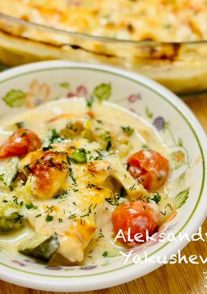 A picture of Chicken breast with vegetables in cheese sauce.