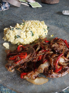 Una foto de Higadito salteado con cebolla y morrón acompañado con un revuelto de verduras y arroz